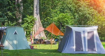 Tuinposter Two field tents with outdoor camping equipment on campground area at natural parkland  © Prapat