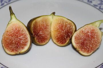 Fresh slice of fig lying on a heap of ripe figs. Heap of tasty organic figs