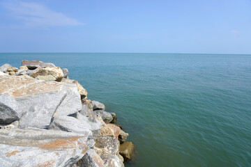 The sea is bordered by large breakwater rocks. sea and rock background. Breaking sea waves on the beach. sea view background concept

