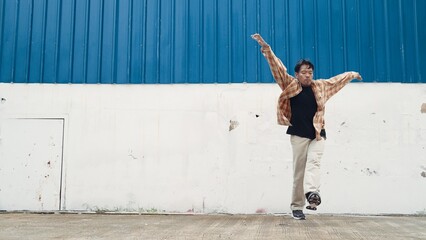 Hispanic funny choreographer dancing in hip hop style. Young happy break dancer perform b-boy...