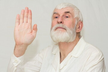 elderly man doctor shows hand palm forward, gesture everything is fine
