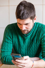 portrait of a handsome young man in a green sweater with a beard