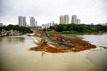 Heavy equipment performs excavation work at a construction site. ongoing. Construction of a...