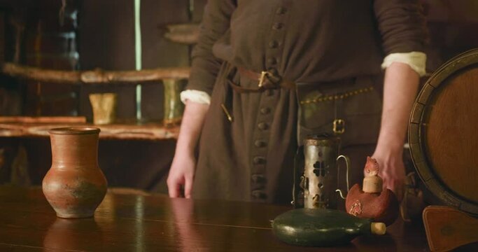 Medieval servant stands at counter in tavern. Dwarf barkeeper with purse on belt ready to sell drinks and goods in public house. Fantasy NPC character