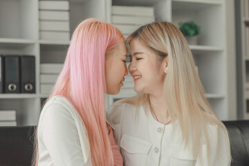 Fototapeta premium LGBT lesbian couple love moments happiness concept, Smiling young lesbian couple, lesbian couple embracing in the living room, Female couple enjoying time together in the house.