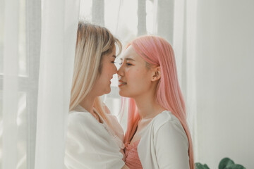 Fototapeta premium LGBT lesbian couple love moments happiness concept, Smiling young lesbian couple, lesbian couple embracing in the living room, Female couple enjoying time together in the house.