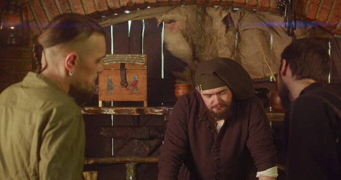 Merchant takes money for goods from strange buyers in tavern. Suspicious servant becomes cheerful seeing cash of guests in medieval inn. Fantasy role-play