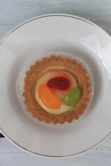 Fruit pie in paper cup in white plate on table