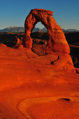Sunset at the Delicate Arch and the distant La Sal Mountains, Arches National Park, Moab, Utah, USA.