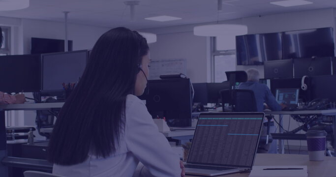 Young biracial woman works diligently at her office desk - Powered by Adobe