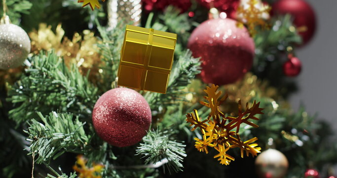 Image of gold christmas decorations over christmas tree background