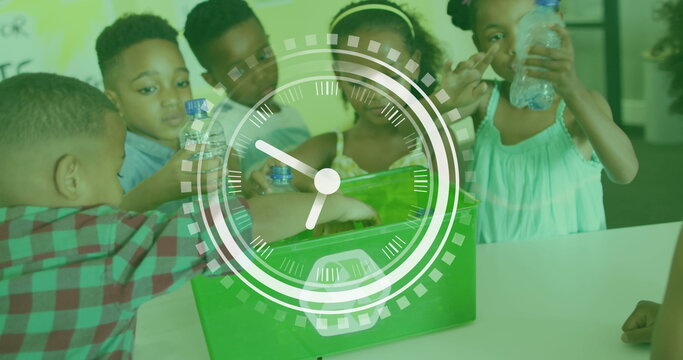 Image of clock over diverse schoolchildren recycling plastic in class