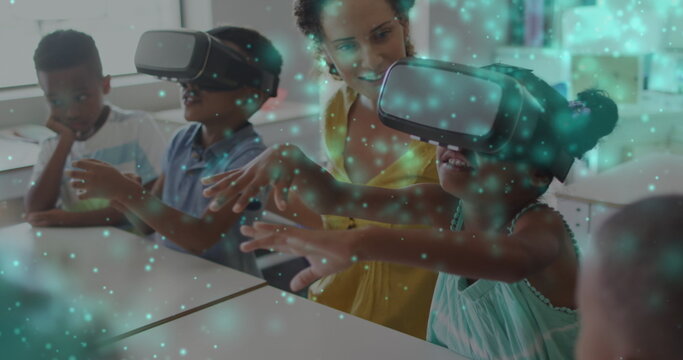 Image of particles of light over diverse female teacher and pupils in vr headsets in classroom