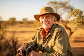 Portrait of an elderly man with binoculars in the bush