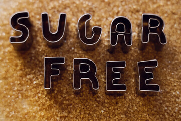 iron word -  cane SUGAR  free made from metal letters on pile of dark Brown sugar as background. no...