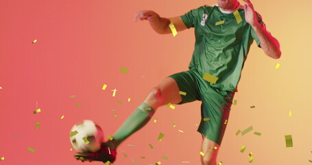 Image of caucasian male soccer player over confetti