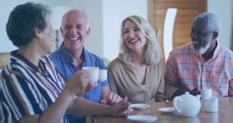Diverse group of friends share laughter over coffee at home