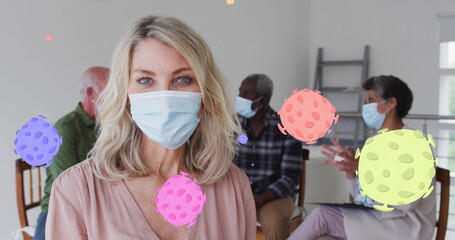Image of virus cells over diverse group of seniors with face masks