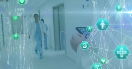 Image of network of digital icons over male doctor using tablet