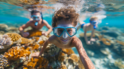 Fototapeta premium Young kids snorkeling underwater of a tropical island during family vacation. 