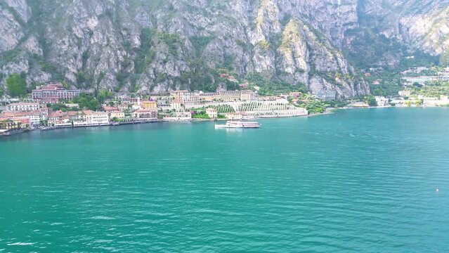 Drone footage of the lakefront buildings and mountains by Lake Garda (Lago di Garda) in Italy
