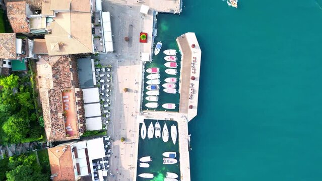 Bird eye view over lakefront boats by shiny Lake Garda in Italy on a sunny day