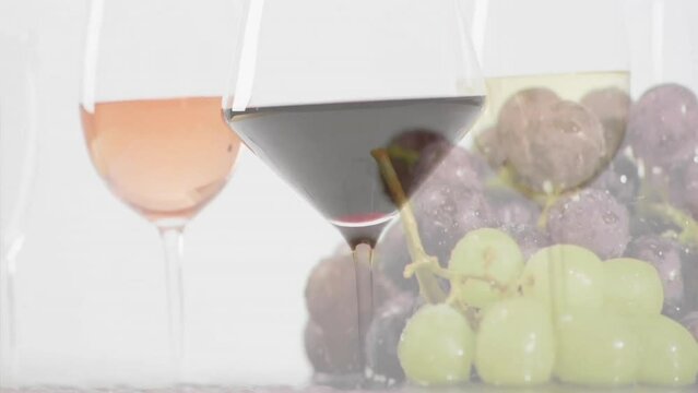 Composite of glasees with white, rose and red wine glasses over grapes on white background