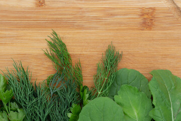 Greens, dill, parsley on a wooden board, close-up