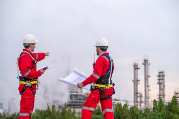 Engineer survey team wear uniform and helmet stand workplace checking blueprint project , radio...