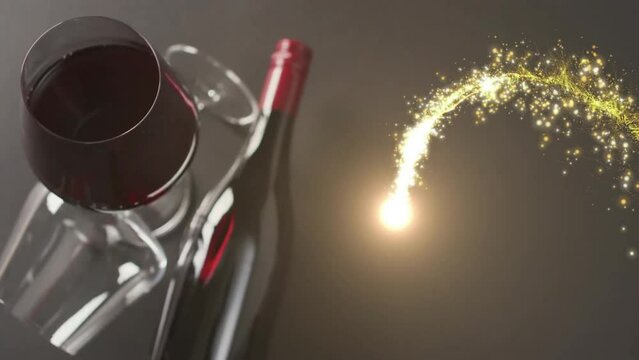 Composite of shooting star over glass and bottle of red wine over black background