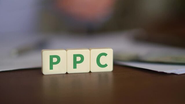 Concept of Pay Per Click advertising. PPC initials with selective focus and money on the background
