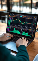 A person use  laptop with stock charts displayed