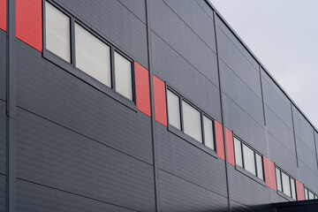 Grey sandwich panel warehouse with red design elements