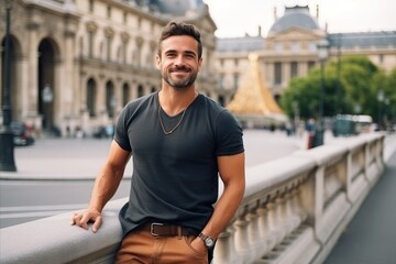 Handsome young man standing on the bridge in Paris, France
