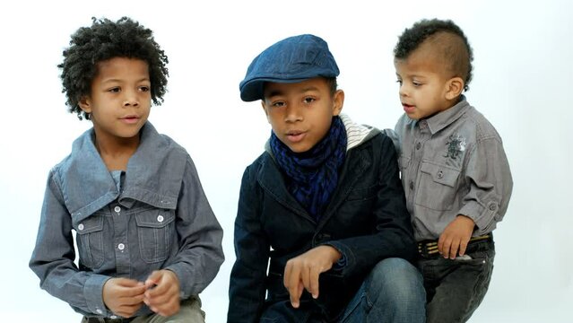 Three cute black boy sings rap and dance. Artistic guys are auditioning on a white background.