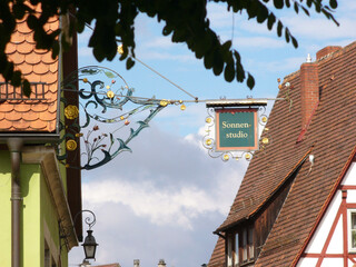 historisches Schild bzw. Zunftzeichen kennzeichnet Sonnenstudio