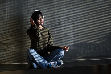 woman in shirt Sitting holding a smartphone, listening to music