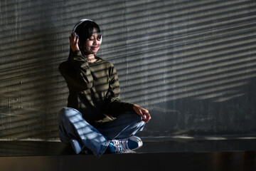 woman in shirt Sitting holding a smartphone, listening to music