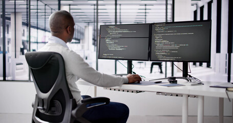 African American Coder Using Computer At Desk