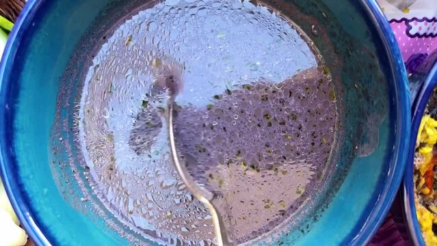 close up view of traditional blue clay bowl and rare delicious purple color traditional food oil bubble organic qurut kasht tasty cuisine gourmet meal dairy dry mint fresh garlic tomato eggplant Iran