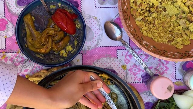Taste traditional food on pink table cloth in Iran khorasan rural countryside traditional purple color food made by tomato eggplant and qurut the kashk dairy salty product local people tourist love it