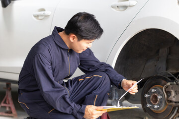 Technician man checking car at garage, Car mechanic with a checklist, Car repair and maintenance...