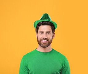 St. Patrick's day party. Man in green leprechaun hat on golden background
