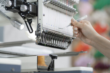 operator of modern automatic equipment pass through a thread on the factory