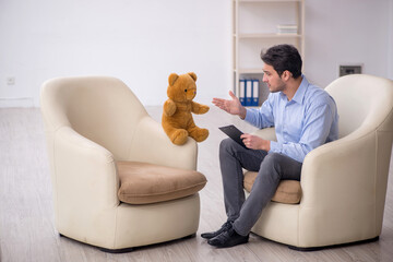 Young male psychologist meeting with toy bear
