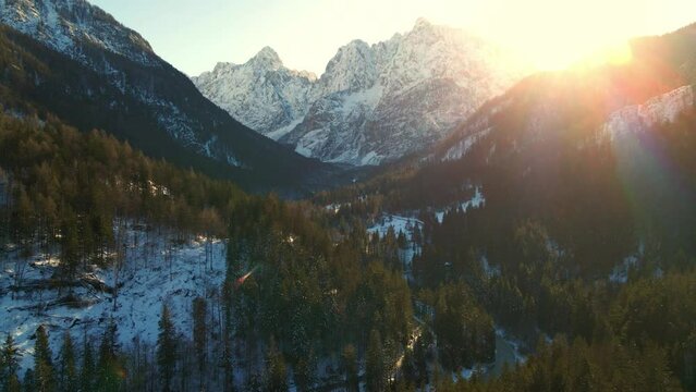 Mountain valley with the river and road in winter. The tops of the mountains are covered with snow. View of the Alps in Kranjska Gora at sunrise. Triglav national park. Slovenia, Europe