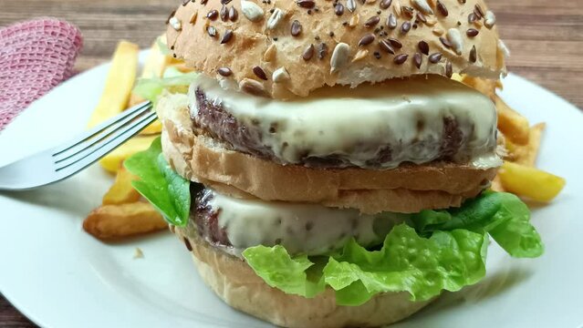 burger double et frites dans une assiette, en gros plan