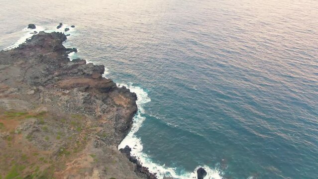 Rocky coastline of Hawaii and foamy Pacific ocean waves, aerial view