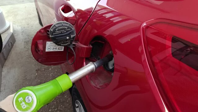 femme mettant du carburant dans sa voiture &agrave; une station service