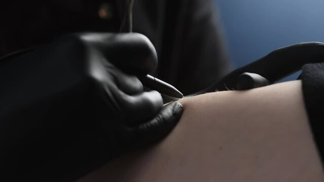The process of removing unwanted hair using a device for electrolysis in a cosmetology office on a dark background. Close-up macro photography.